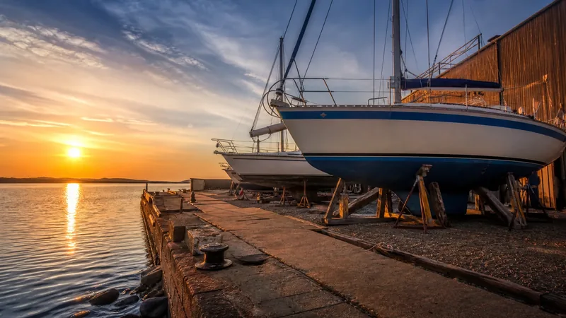 Small boatyard with boats on stands beside calm water, How to Start a Great Lakes Charter Fishing Business